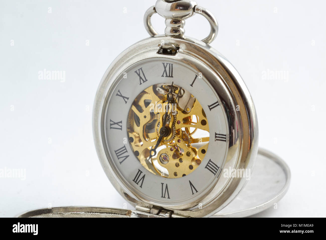 isolated vintage pocket watch with exposed gears, see through body and spring powered Stock Photo
