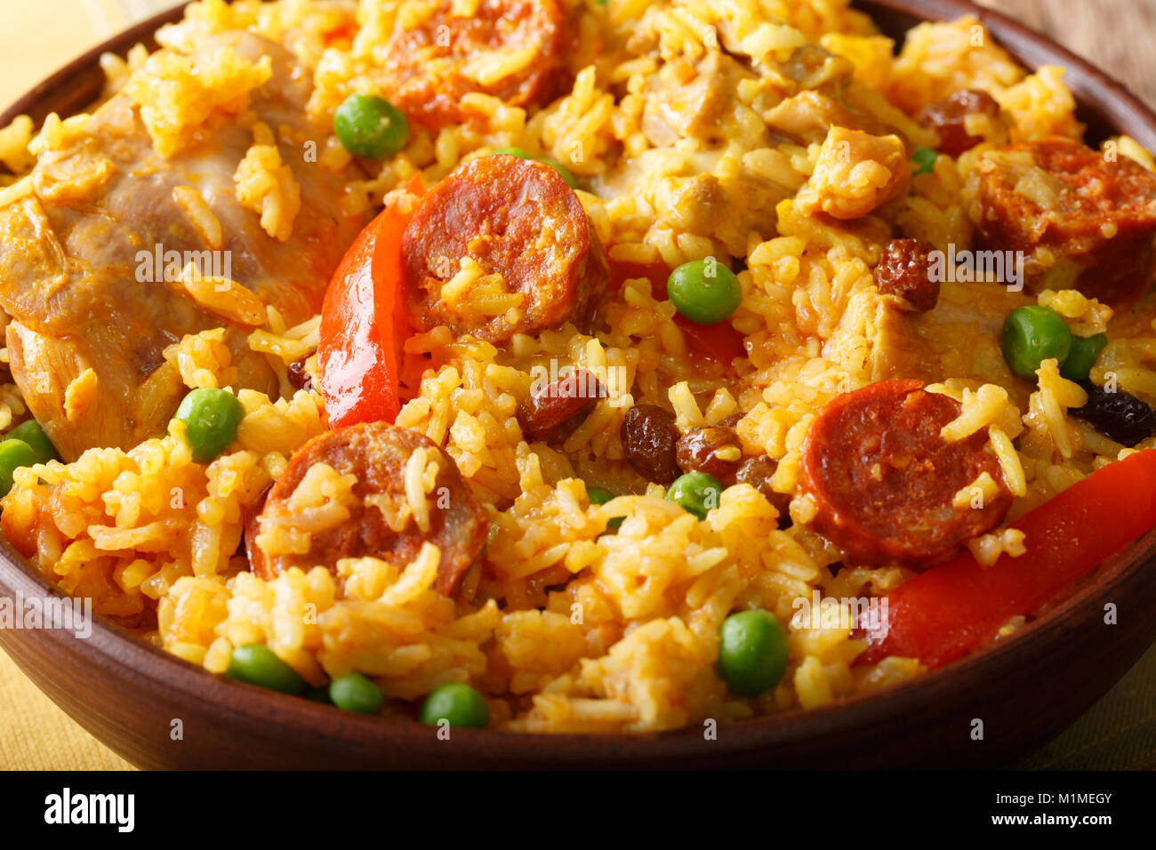 Arroz Valenciana with rabbit, chorizo, vegetables and spices macro in a bowl on the table. horizontal Stock Photo