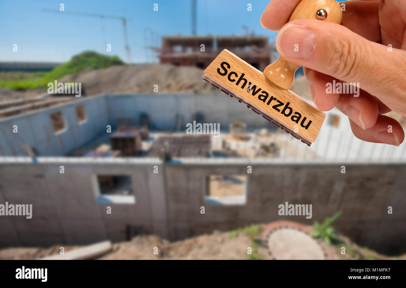 illegal construction printed on rubber stamp in front of new house construction Stock Photo