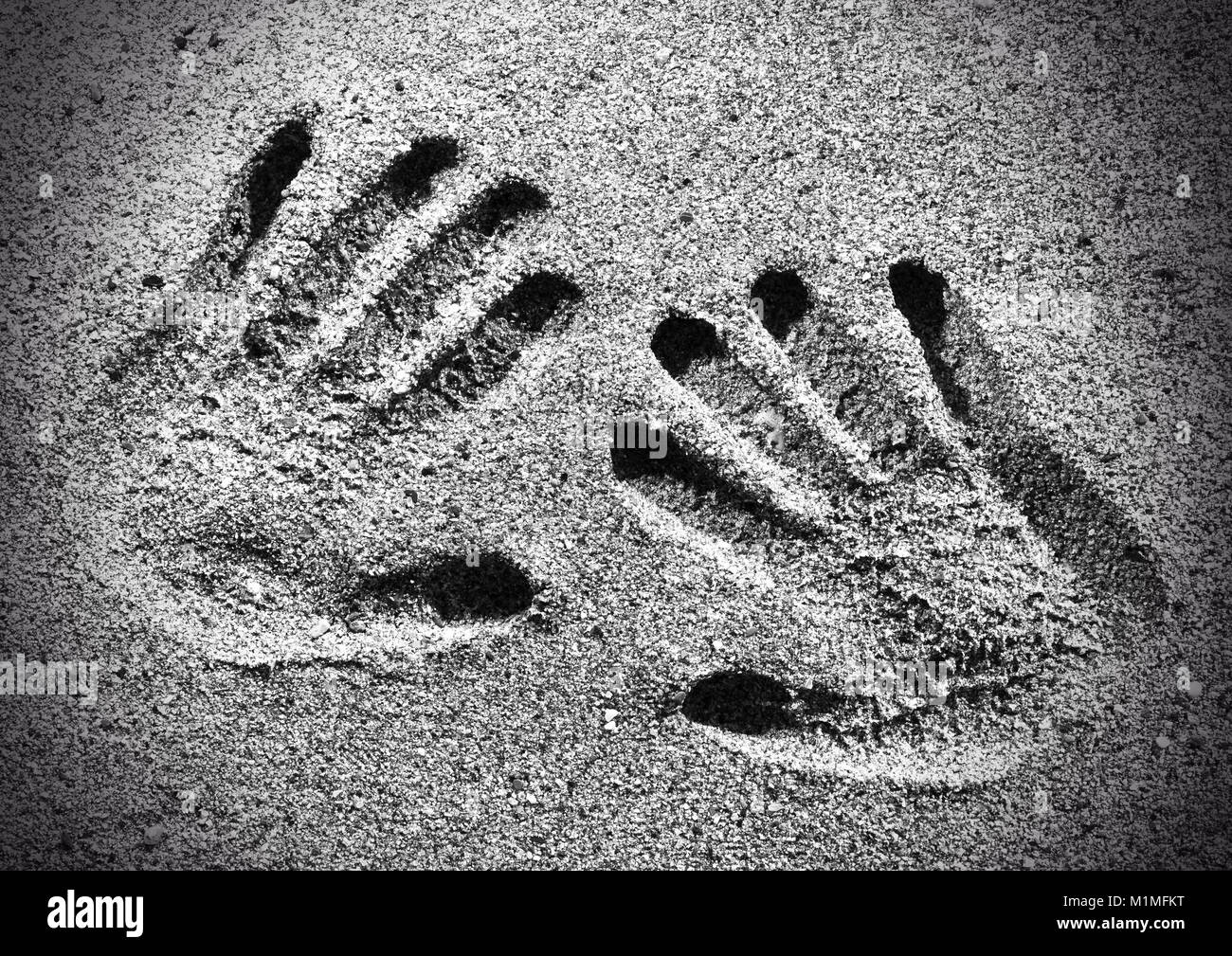 Left and right hand prints in the sand Stock Photo