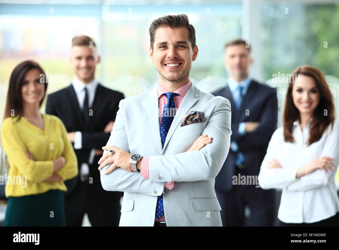 Happy business team with arms crossed at the office Stock Photo - Alamy