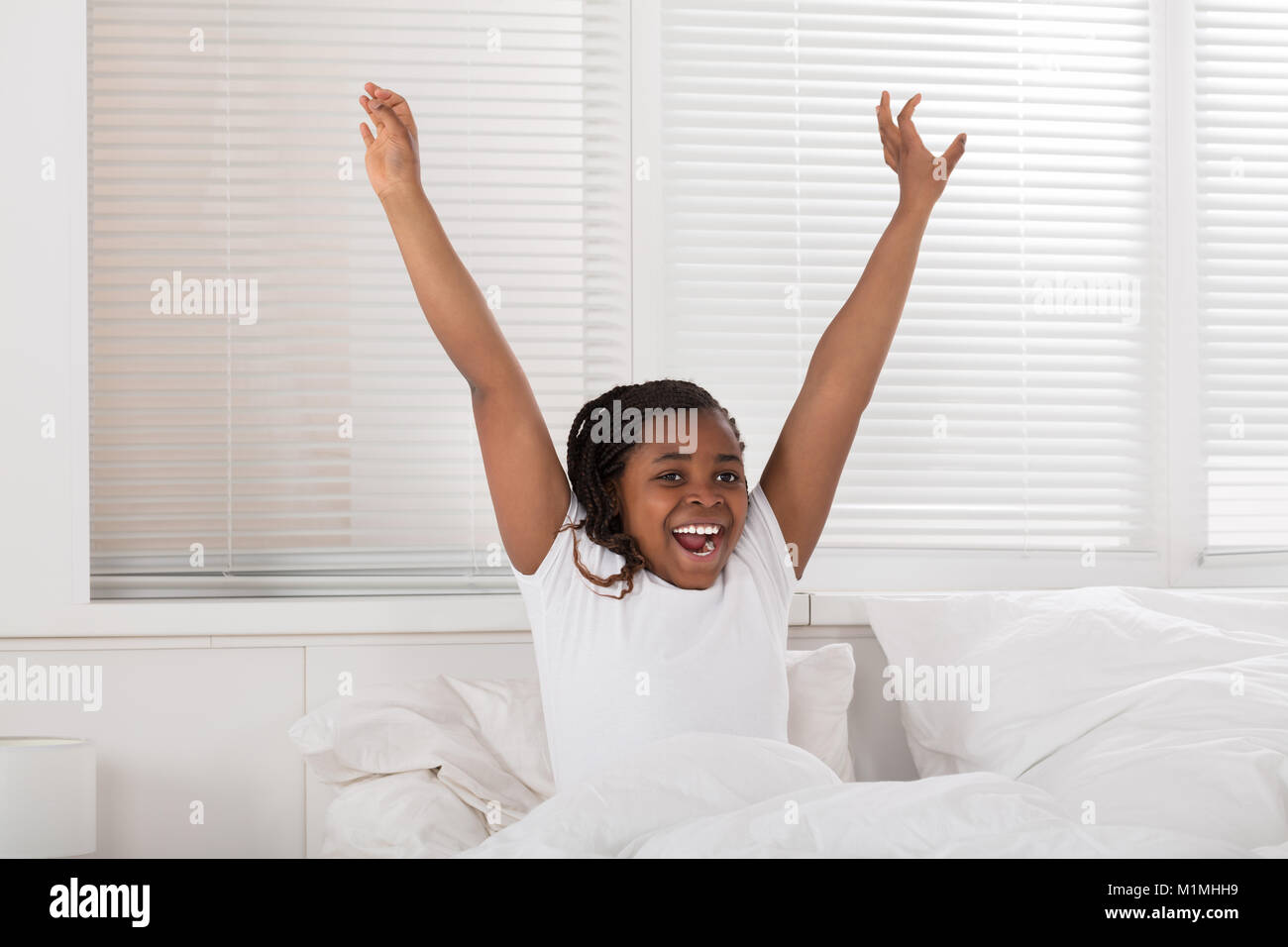Happy Smiling African Girl Waking Up In Morning Stock Photo