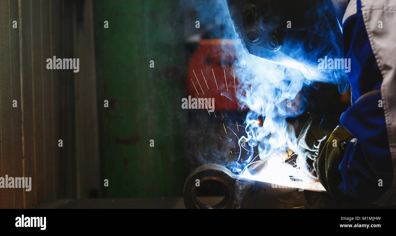 man welds at the factory working in metal industry Stock Photo