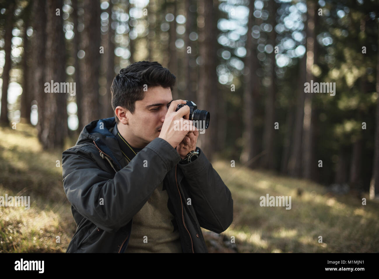 Man standing in forest taking photos Stock Photo