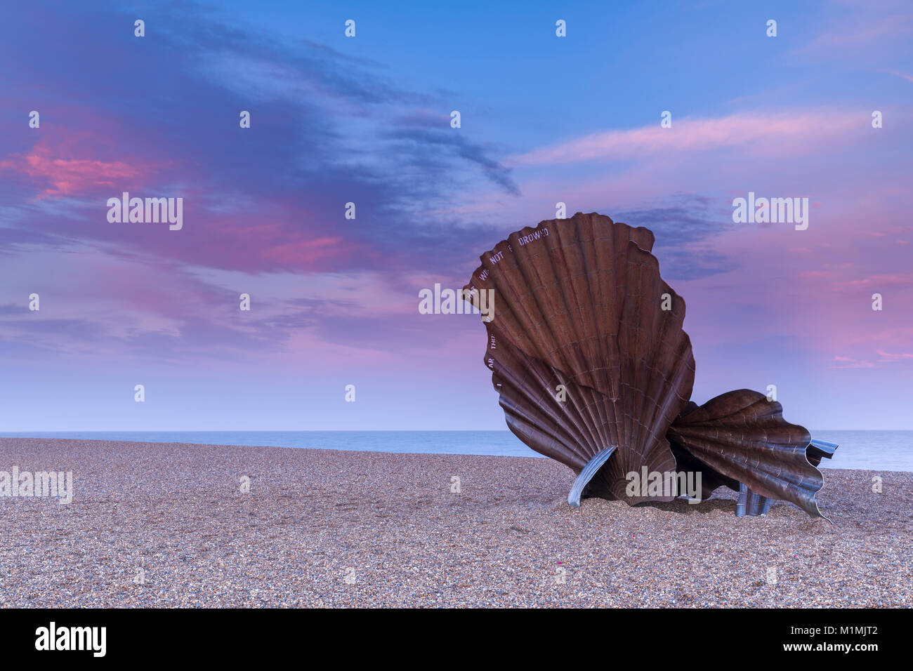 Scallop Shell Sculpture at Sunset with beautiful pink sky on Aldeburgh Beach in Suffolk, England Stock Photo