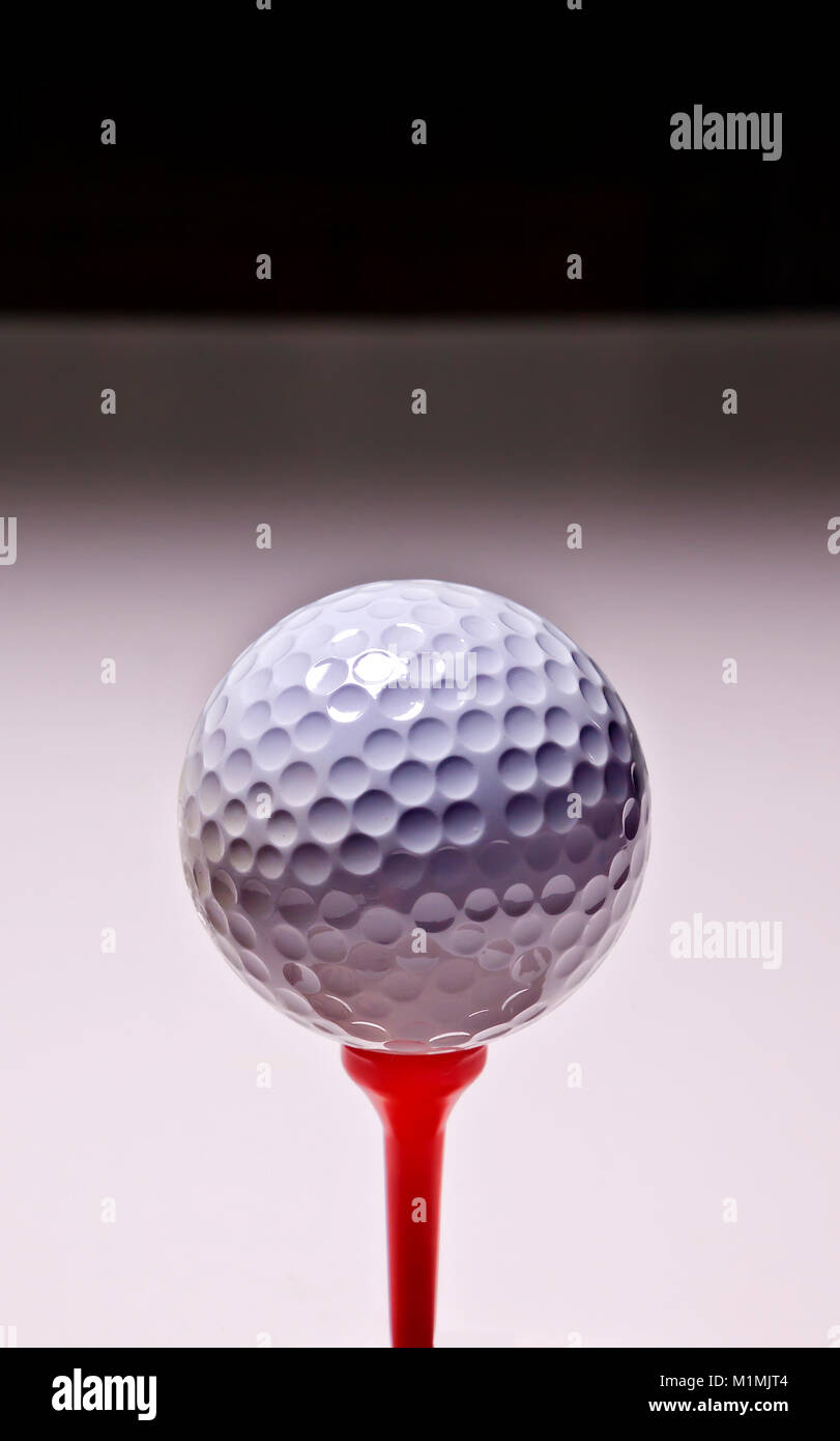 White golf ball on red tee peg Stock Photo