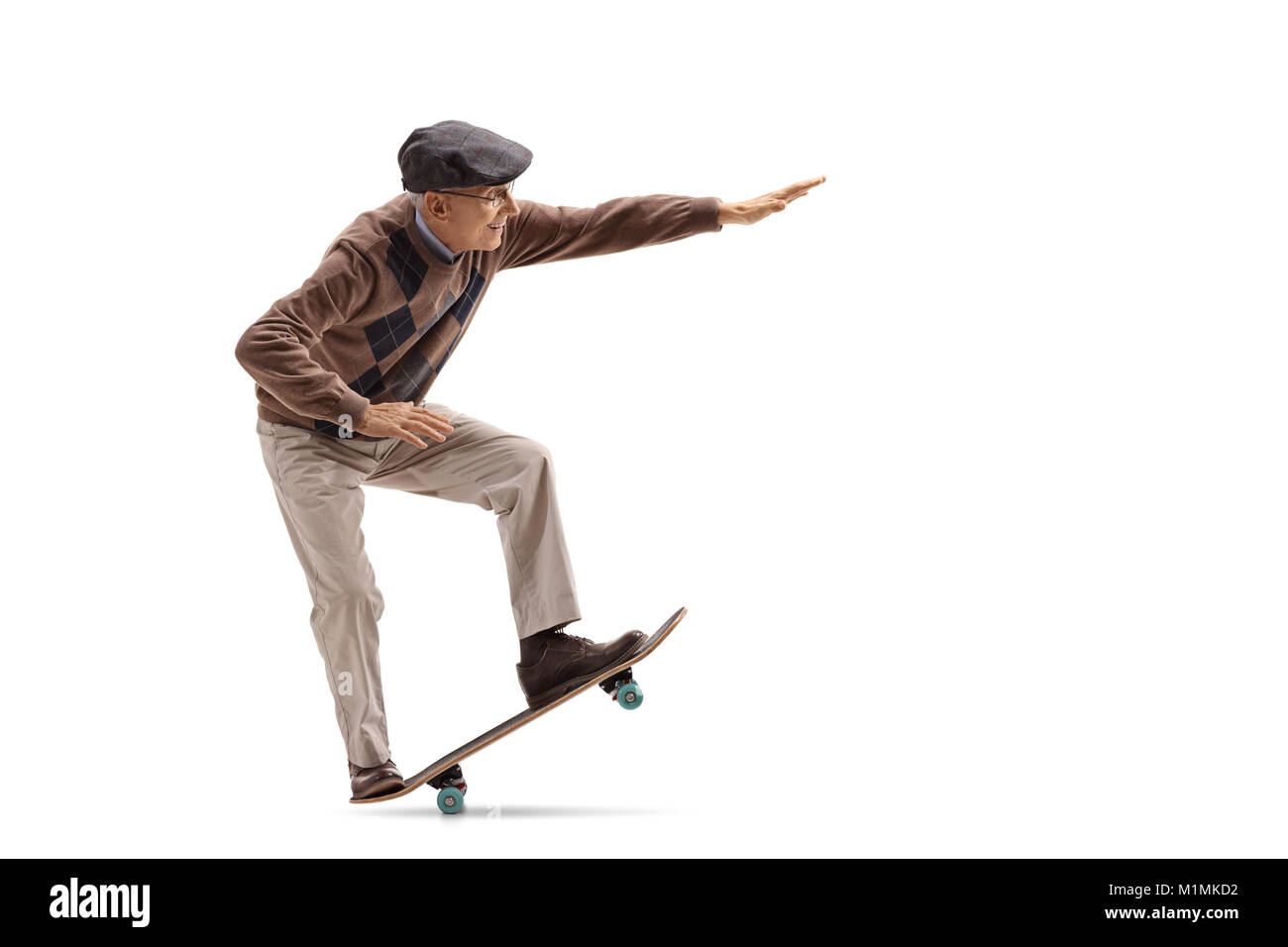Full length profile shot of a senior riding a skateboard and doing a manual isolated on white background Stock Photo