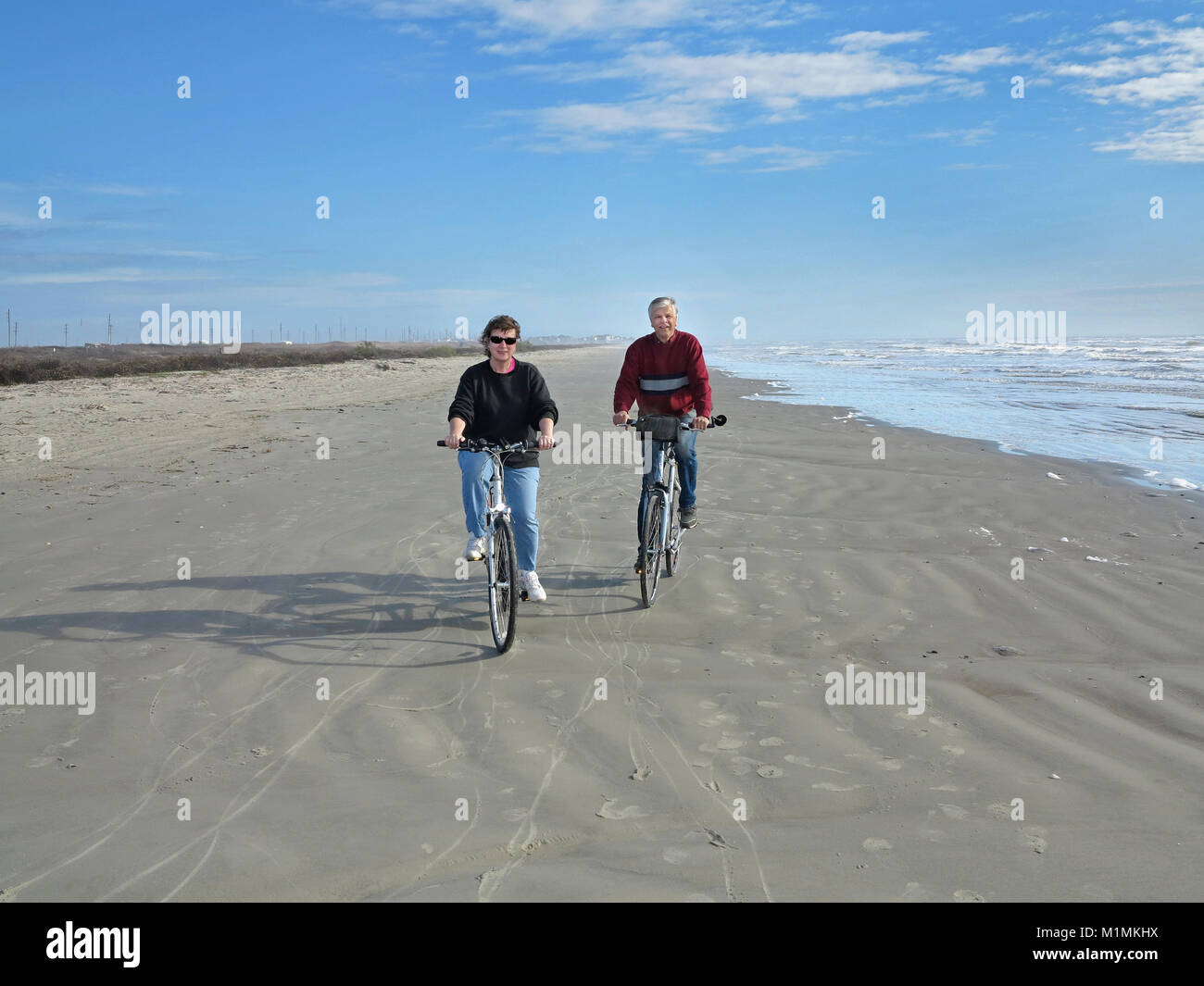 Active couple bicycling on Mustang Island, Corpus Christi, Texas, USA Stock Photo