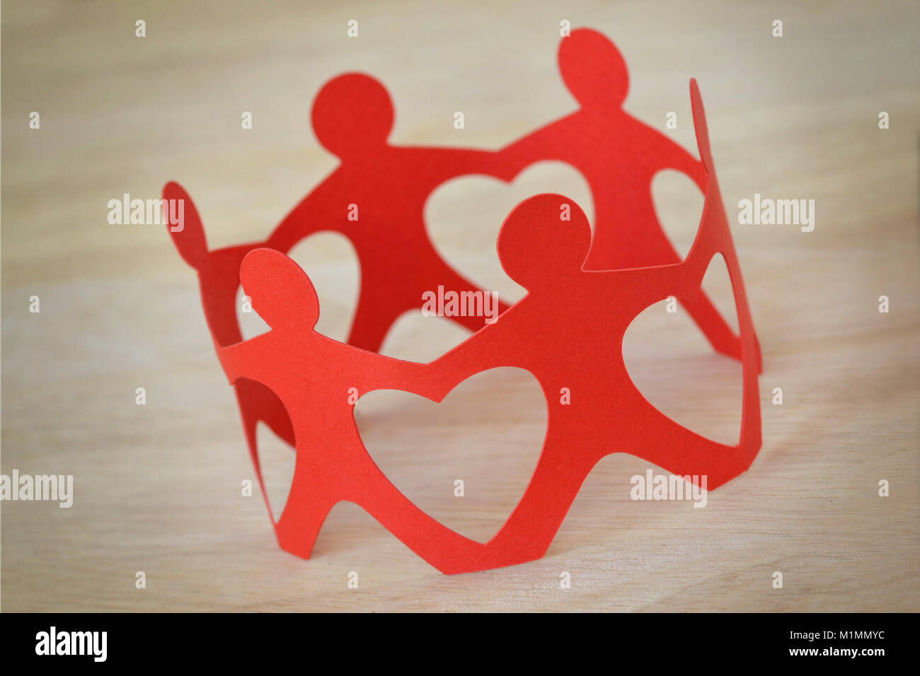 Paper people in a circle holding hands - Teamwork and love concept Stock Photo