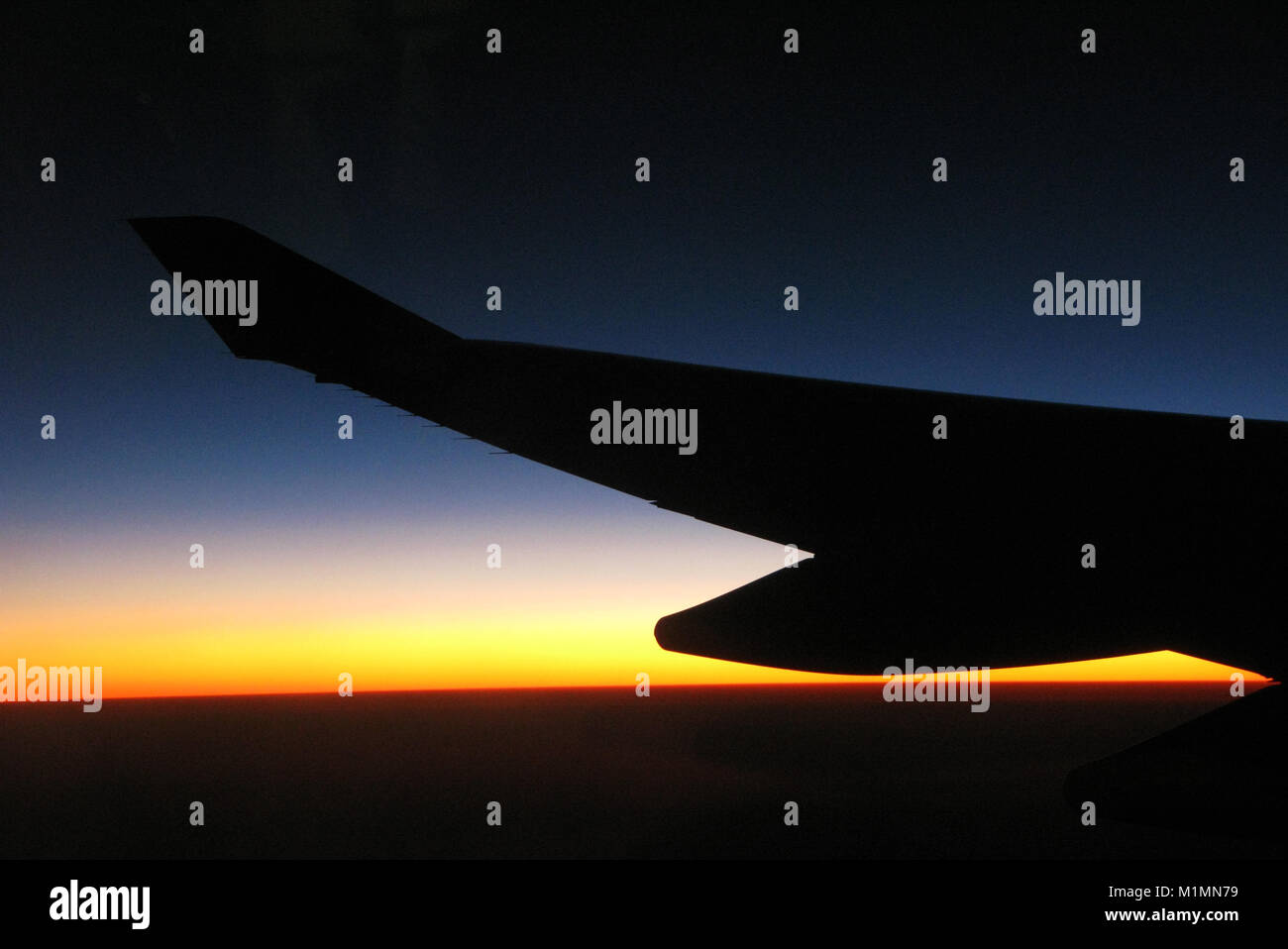 Dawn/ sunrise from 35,000 feet, including plane wing Stock Photo