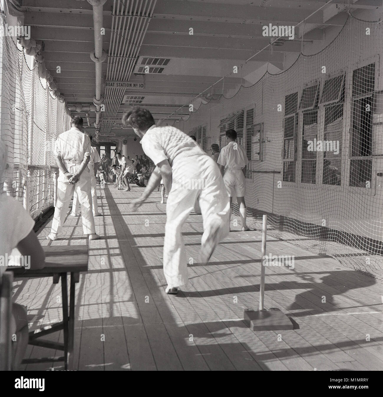 1950s, historical, male passengers and crew playing a game of deck cricket. They are travelling on a Union-castle steamship, carrying mail, cargo and people on a sea voyage to the Cape in South Africa, which for many it will be their permanent home, as they start a new life away from the gloom of post-war Britain. Stock Photo