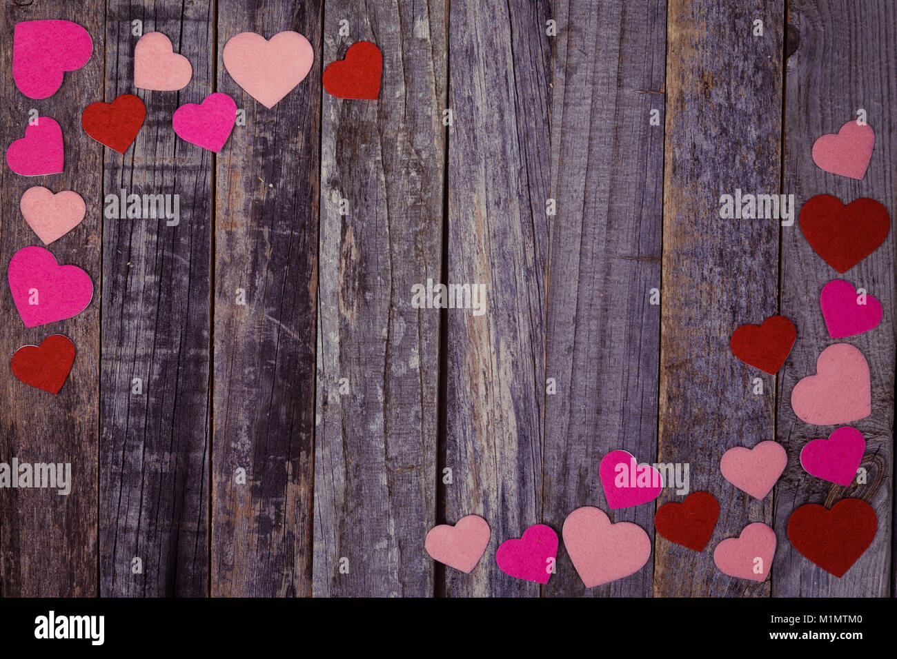 Heart shaped confetti on vintage wooden background. Flat lay, top view