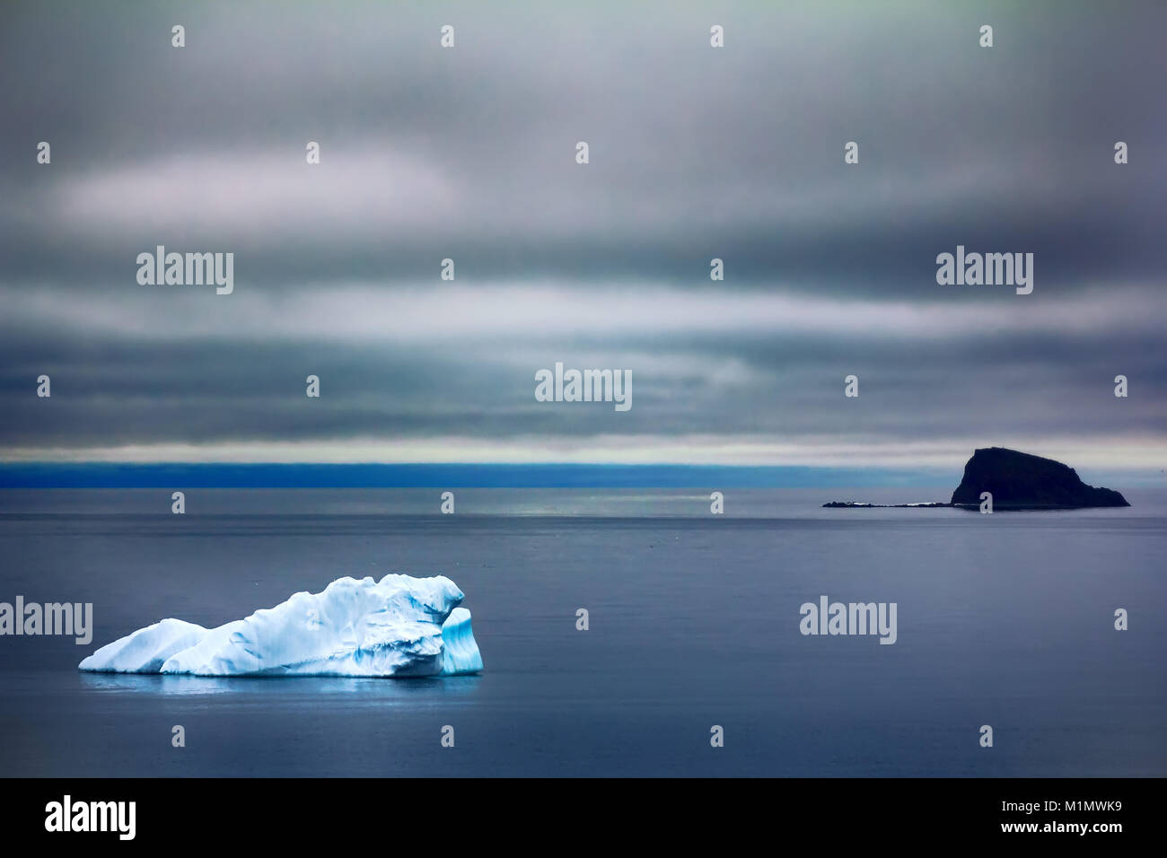 Black and white icebergs formed from single glacier. Black iceberg is