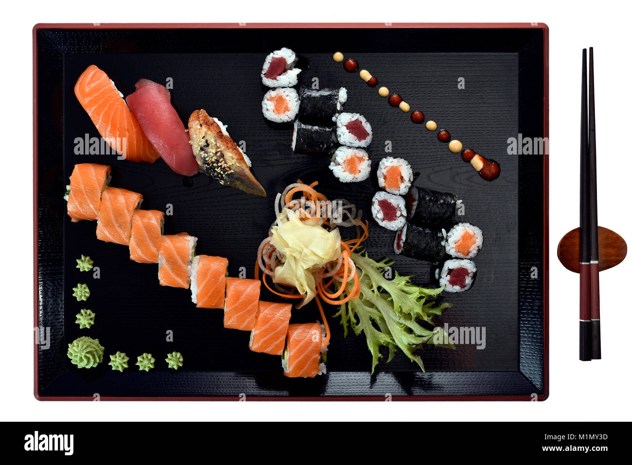 With maki sushi, nigiri, UraMaki court with salmon, tuna, eel, fresh ginger, wasabi, chopsticks, on Japanese wooden plate, Sushi-Gericht mit Maki, Ura Stock Photo