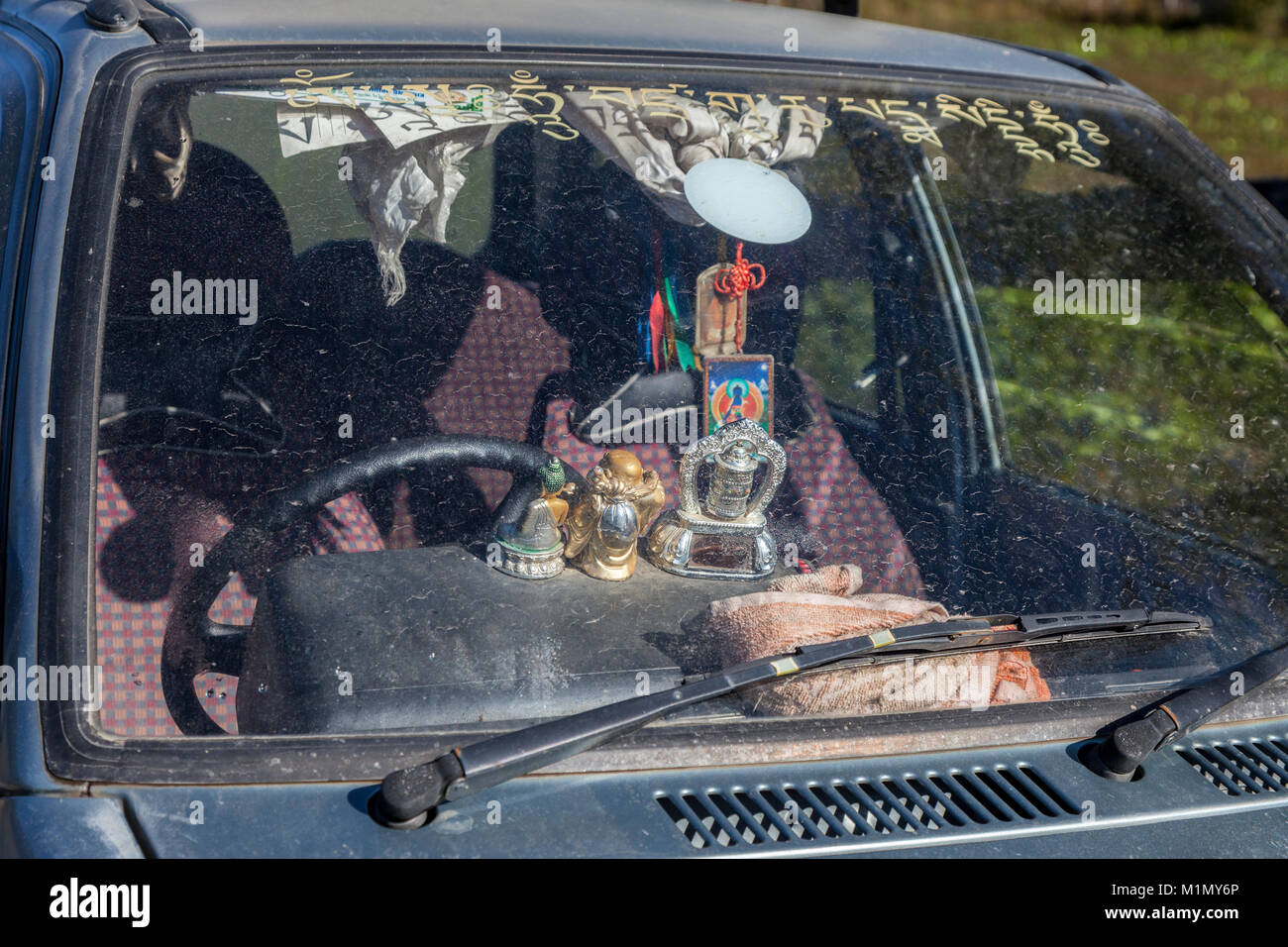 Jakar, Bumthang, Bhutan.  Religious Talismans Resting on a Car's Dashboard. Stock Photo
