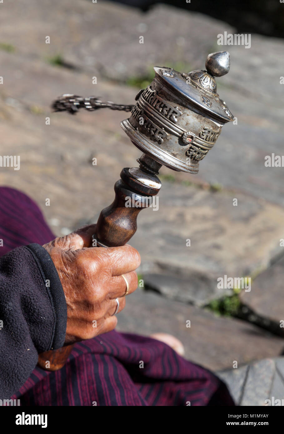 Bumthang, Bhutan. Old Woman's Prayer Wheel, Kurje Lhakhang Buddhist Temple and Monastery. Stock Photo