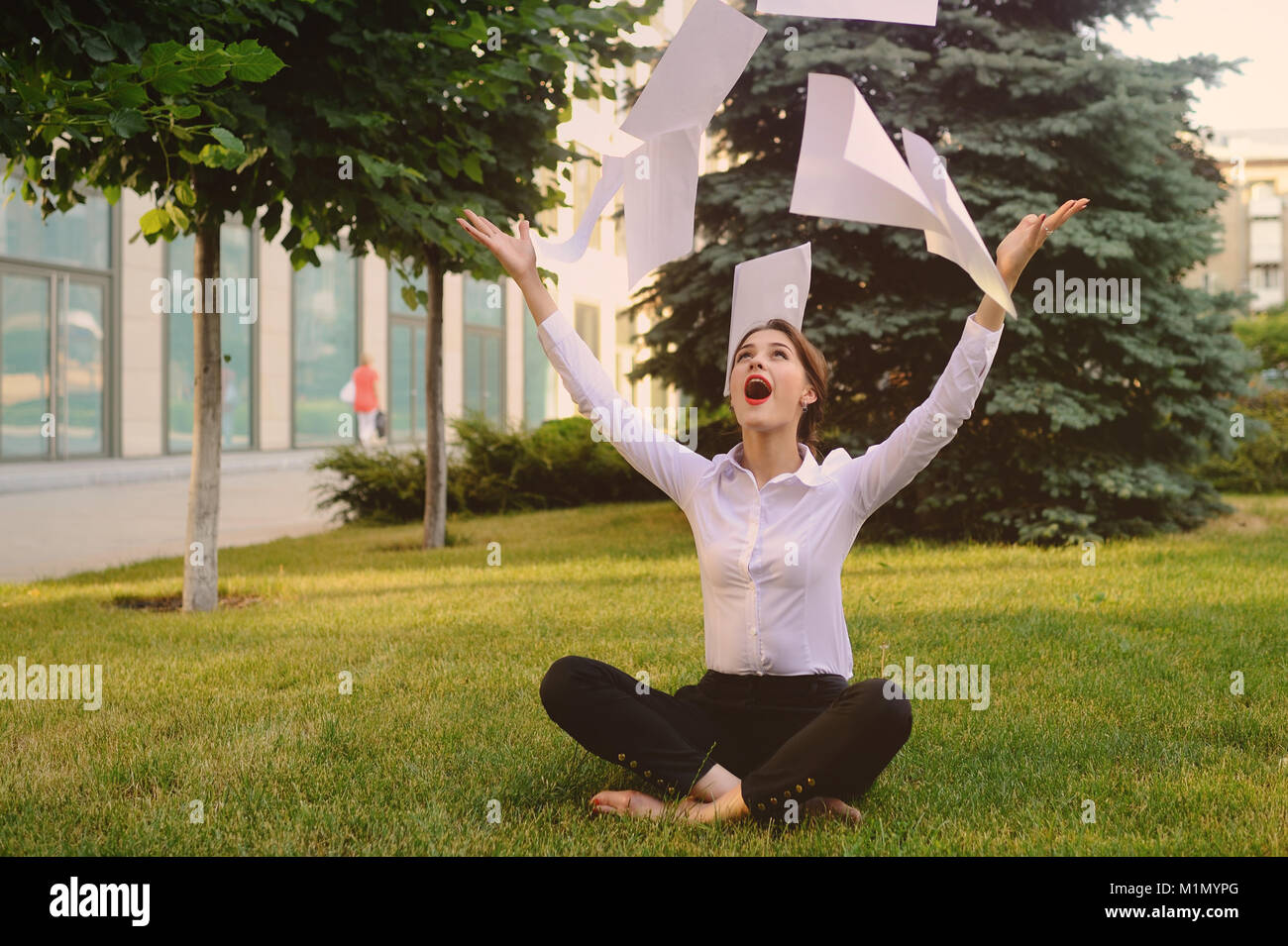 Girl in business office clothes sitting on grass Stock Photo Alamy