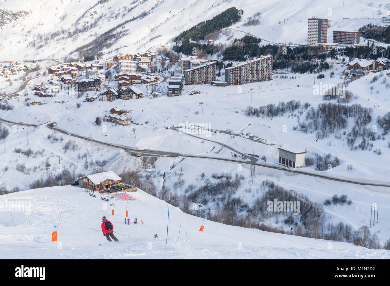 Skiing on La Masse in the Three Valleys ski area of France. Across the valley there is a view of the lower part of the Les Menuires ski resort. Stock Photo