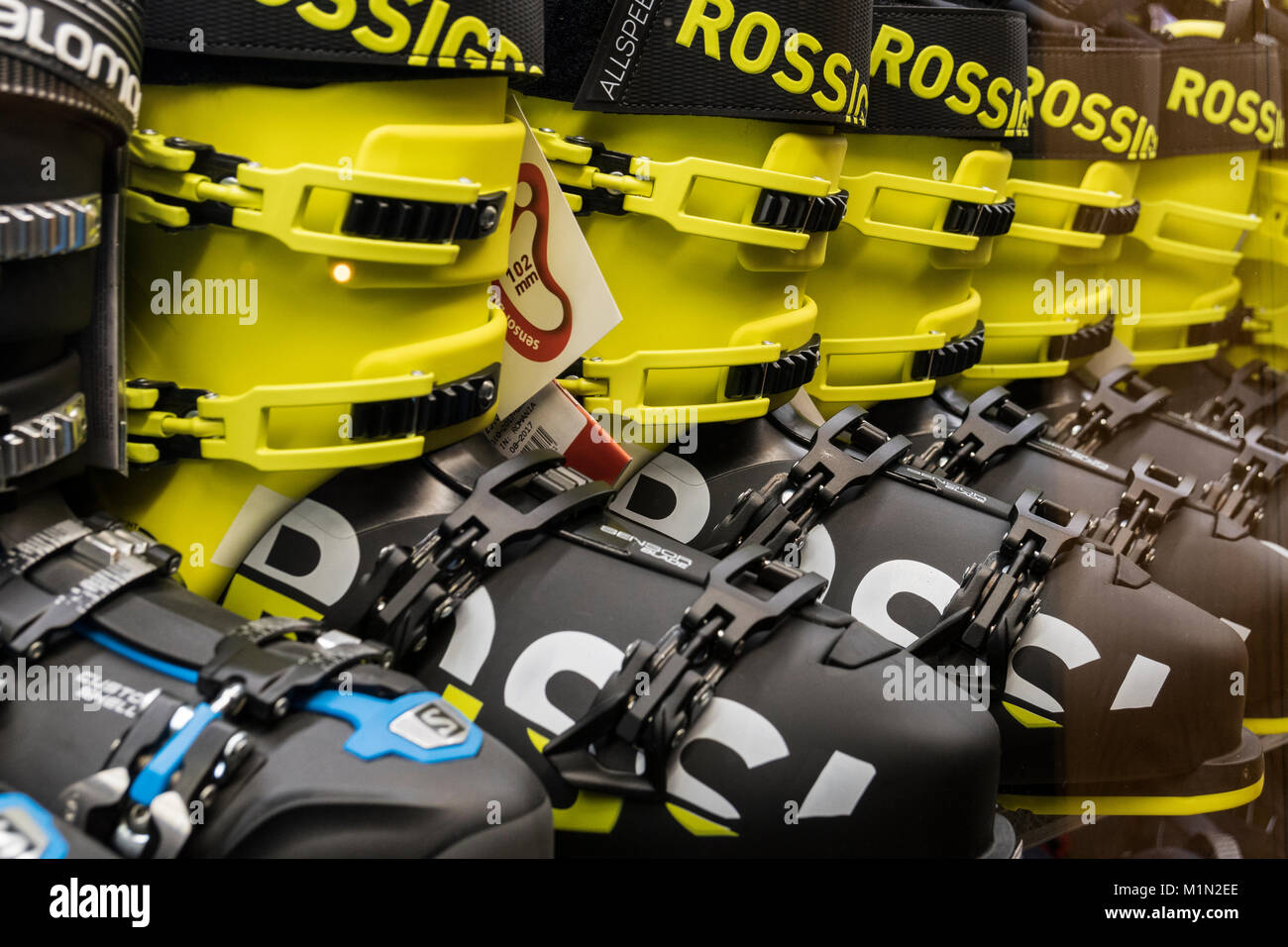 A row of brand new yellow and black Rossignol ski boots in a shop window in the commercial centre of the French ski resort of Les Menuires Stock Photo