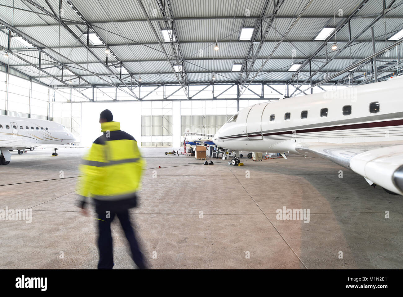 Airport workers check an aircraft for safety in a hangar Stock Photo