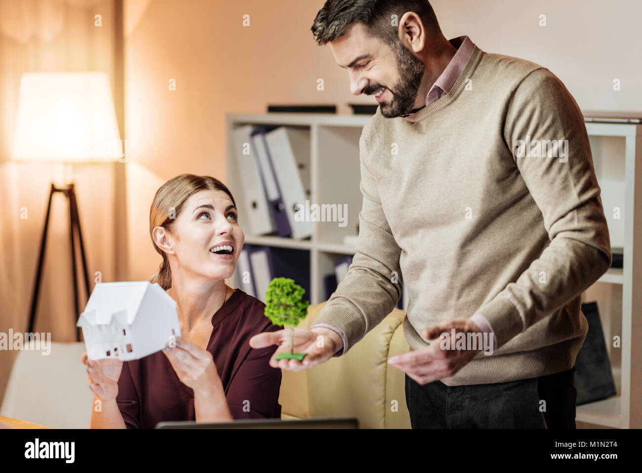 Happy woman holding model of house Stock Photo - Alamy