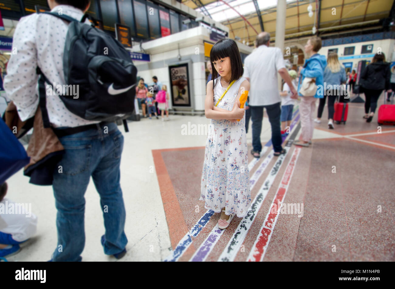 London, UK. Young Japanese girl in Victoria Station Stock Photo