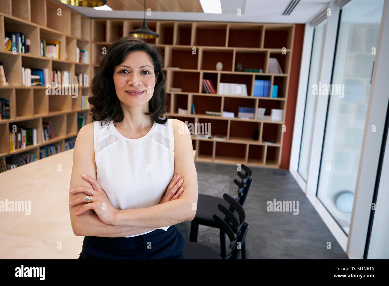Middle aged female creative smiling to camera in her office Stock Photo