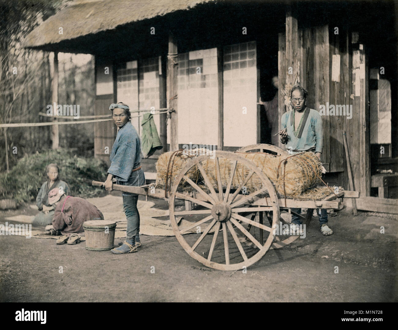 c.1880's Japan - farm labourers pulling a cart with bales Stock Photo