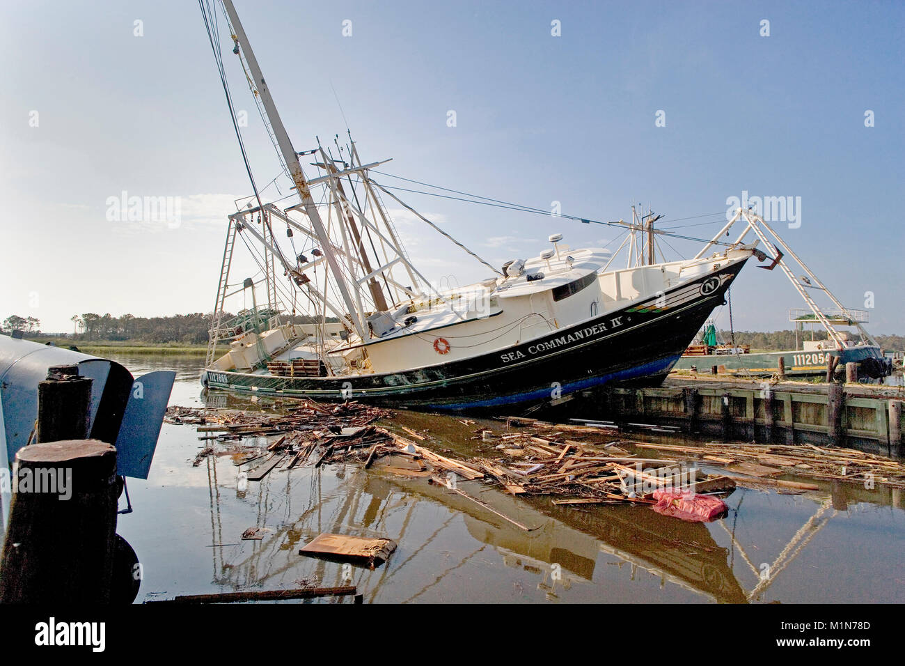 The deep sea trawler, Sea Commander IV,  left crashed upon the docks by the waves and storm surge at Bayou La Batre, Alabama after hurricane Katrina.  Stock Photo