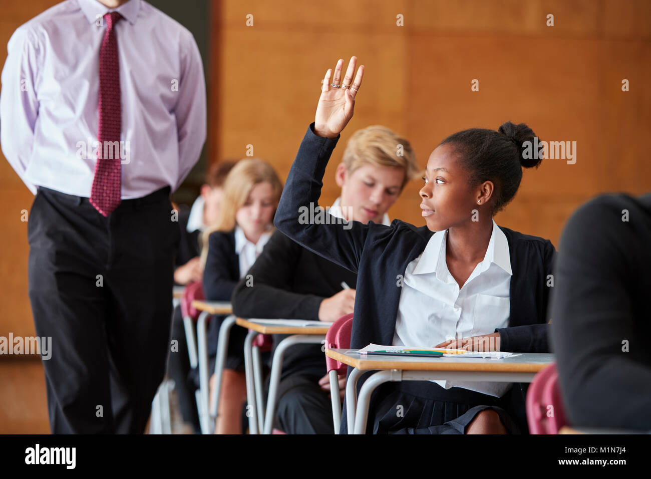 Teenage Student Sitting Examination Asking Teacher Question Stock Photo