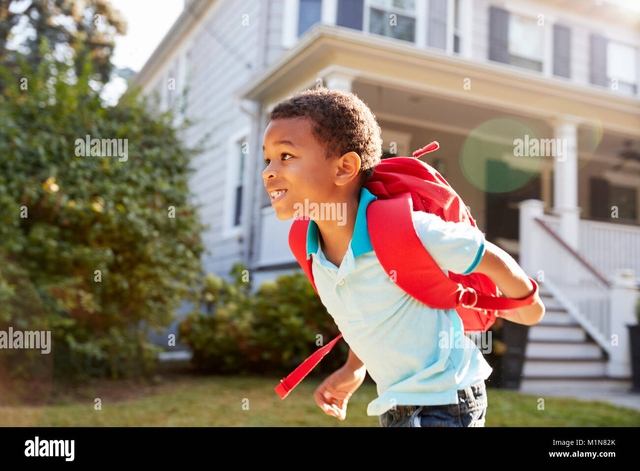 Young Boy Leaving House To Walk To School Stock Photo