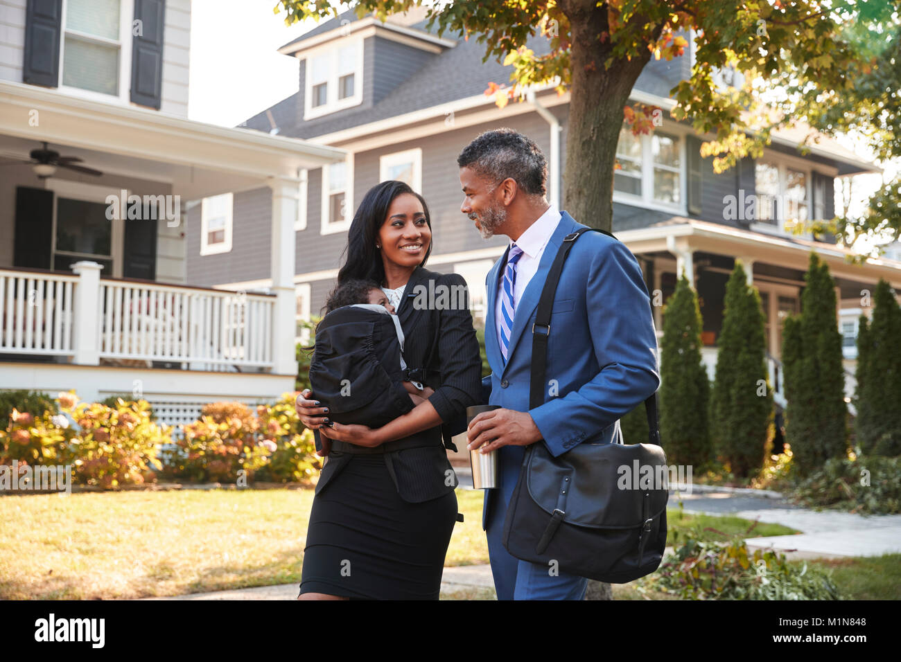 Business Couple With Baby Son Leaving House For Work Stock Photo