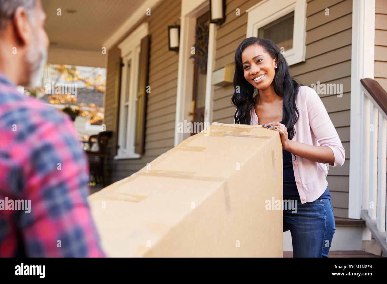 Couple Carrying Big Box Purchase Into House Stock Photo