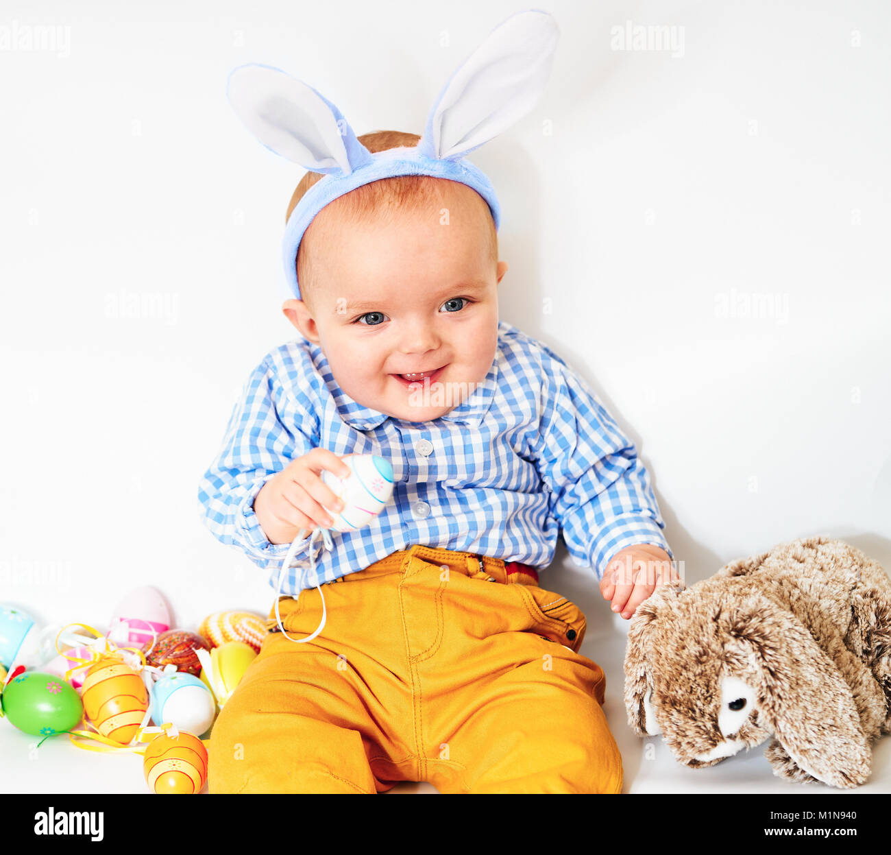 Happy baby boy with bunnies ears on white Stock Photo