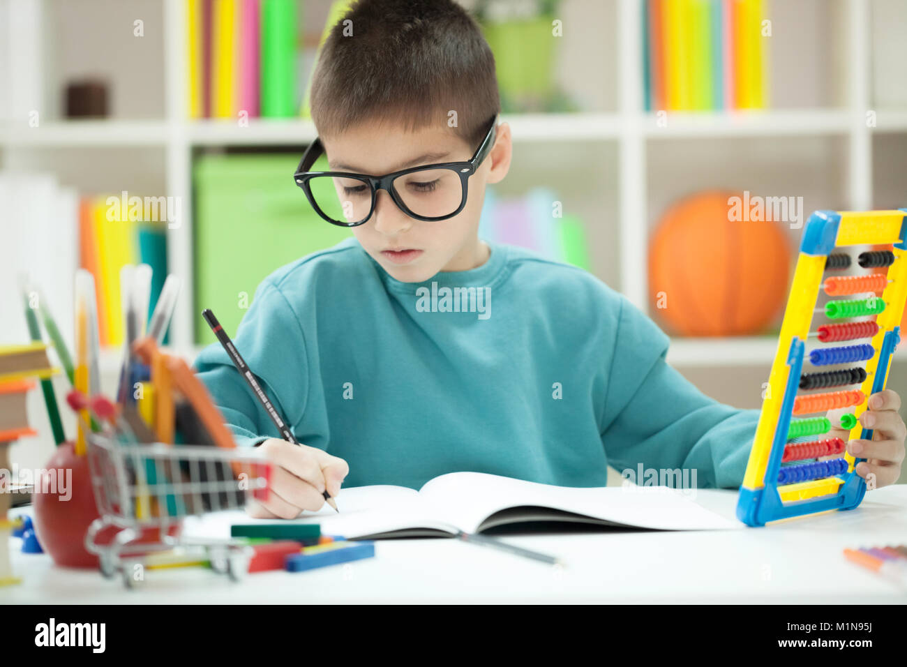 little boy teaches and writes something in a notebook Stock Photo