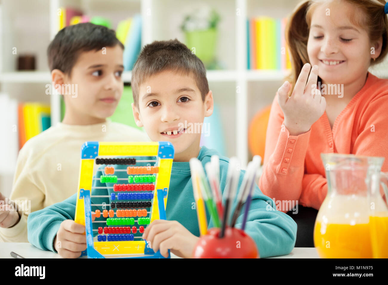 brothers and sisters together  learn math on abacus at home Stock Photo