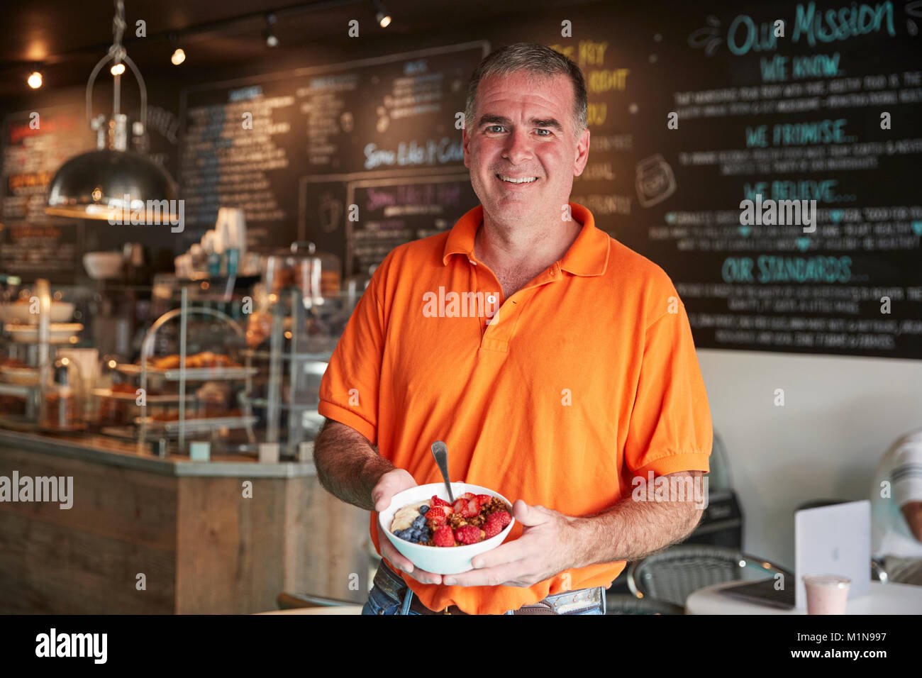 Mature Man Holding Healthy Breakfast In Coffee Shop Stock Photo