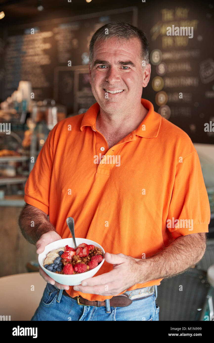 Mature Man Holding Healthy Breakfast In Coffee Shop Stock Photo