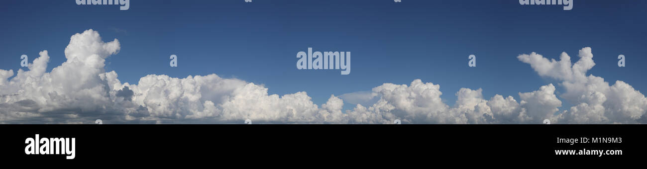 Fluffy white clouds in a blue sky Stock Photo - Alamy