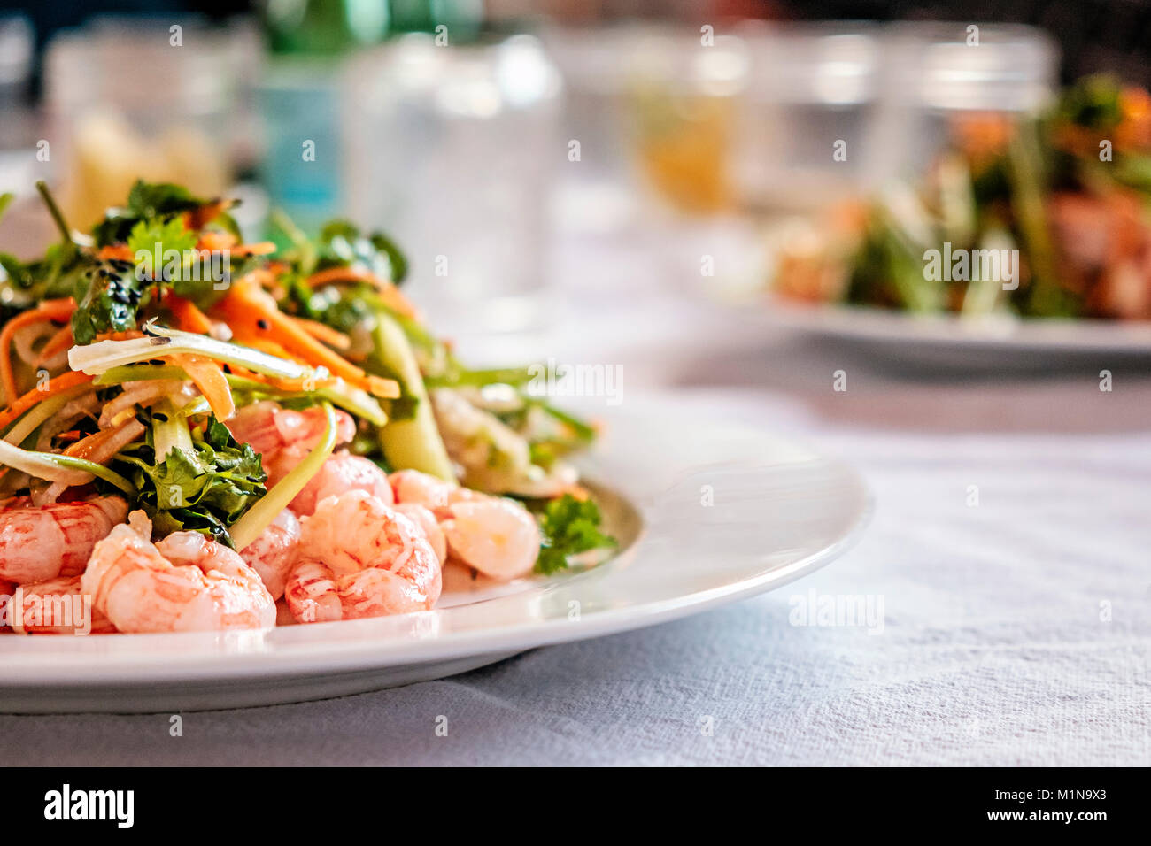 Poached and chilled side stripe shrimp, with watercress, lemon, and pickled carrot salad Stock Photo