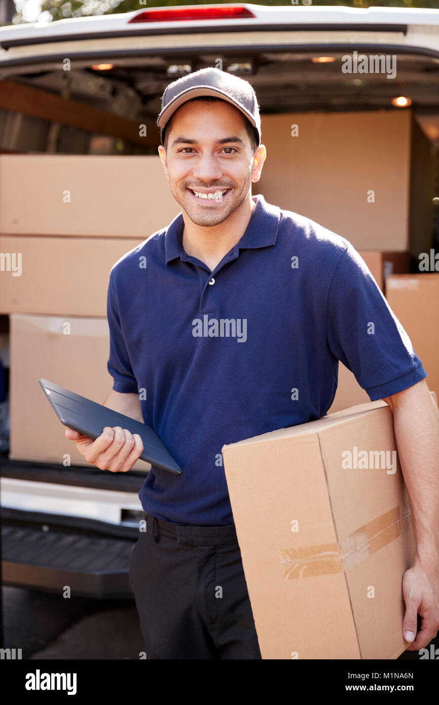 Portrait Of Courier With Digital Tablet Delivering Package Stock Photo