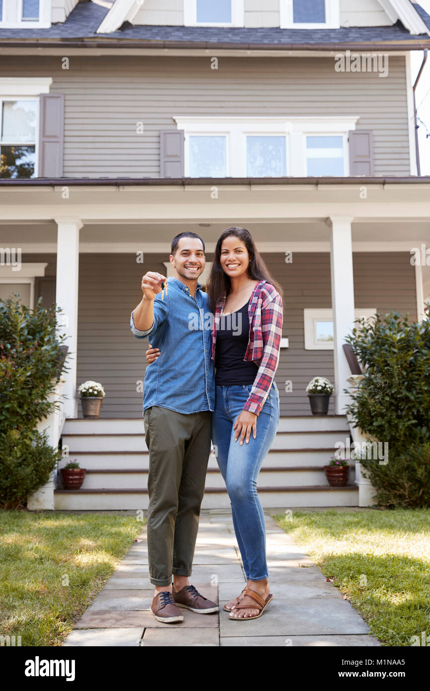 Portrait Of Couple Holding Keys To New Home On Moving In Day Stock Photo