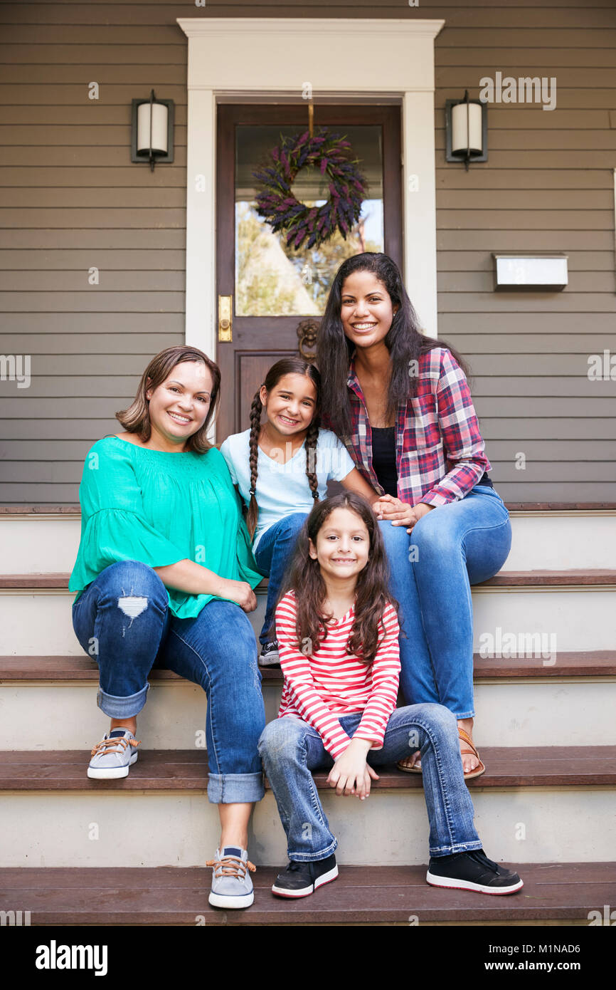 Female Multi Generation Family Sit On Steps in Front Of House Stock Photo