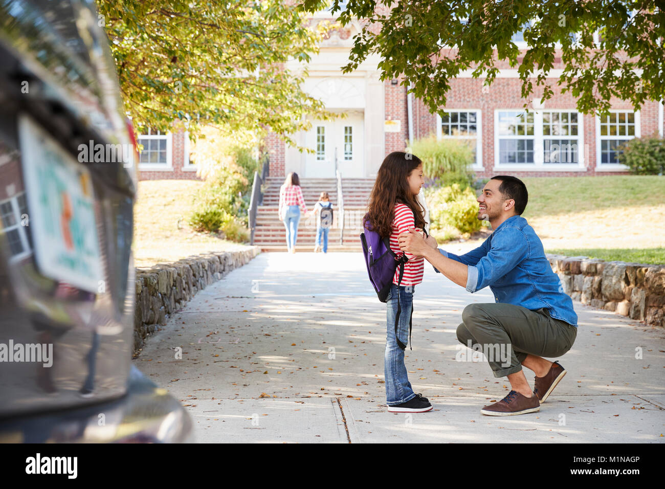 Father Dropping Off Daughter In Front Of School Gates Stock Photo