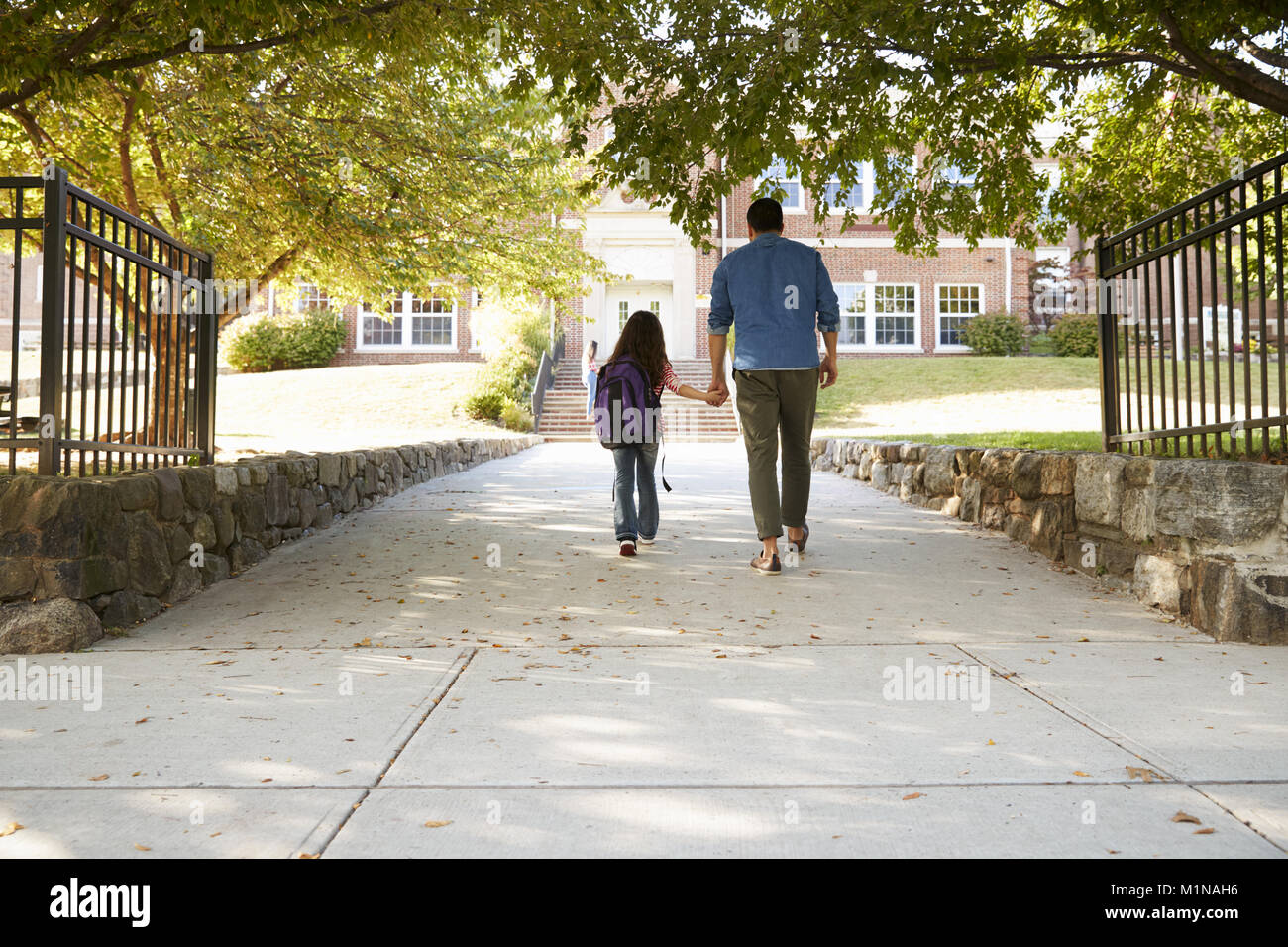Father Dropping Off Daughter In Front Of School Gates Stock Photo