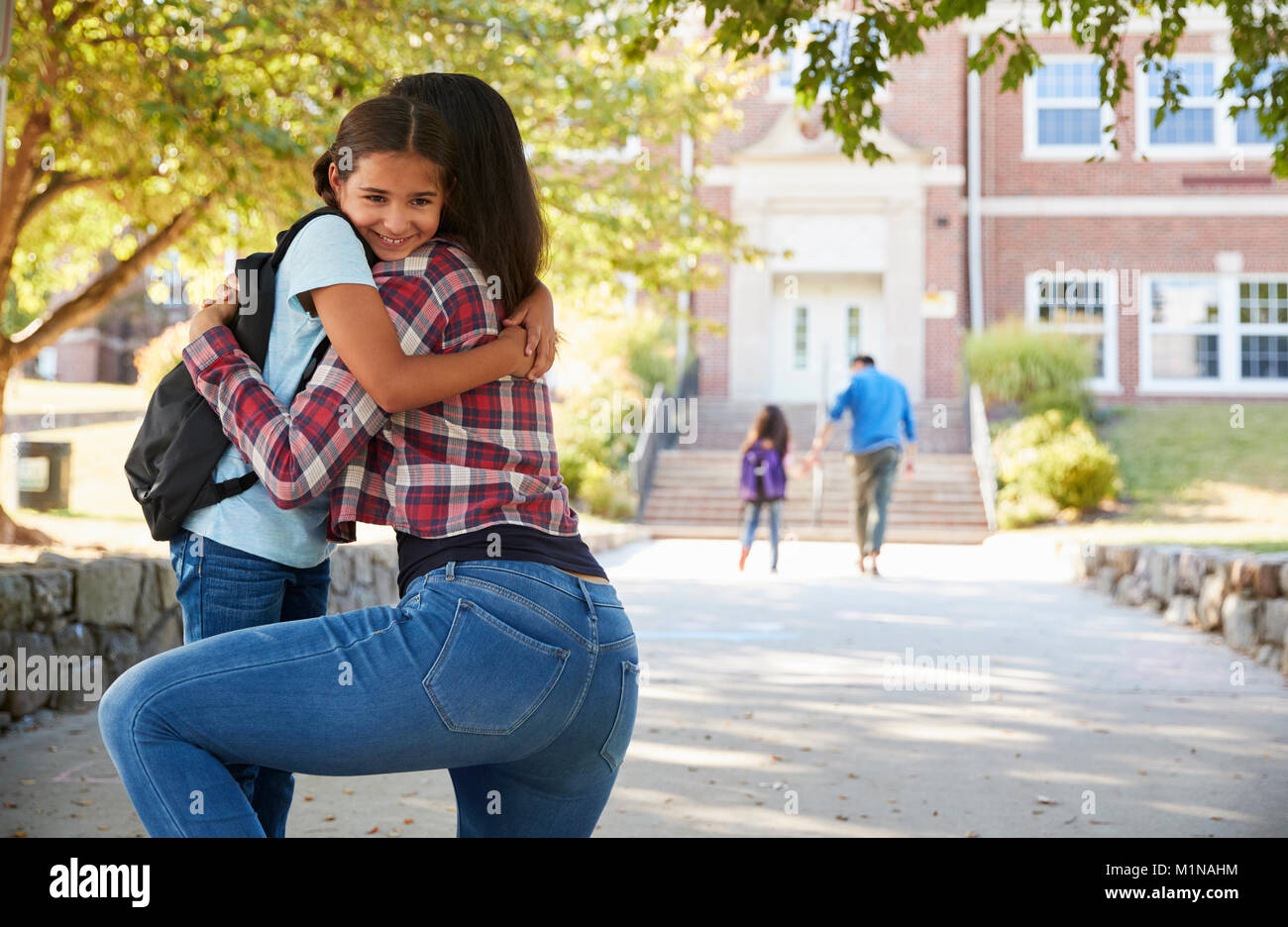 Mother Dropping Off Daughter In Front Of School Gates Stock Photo