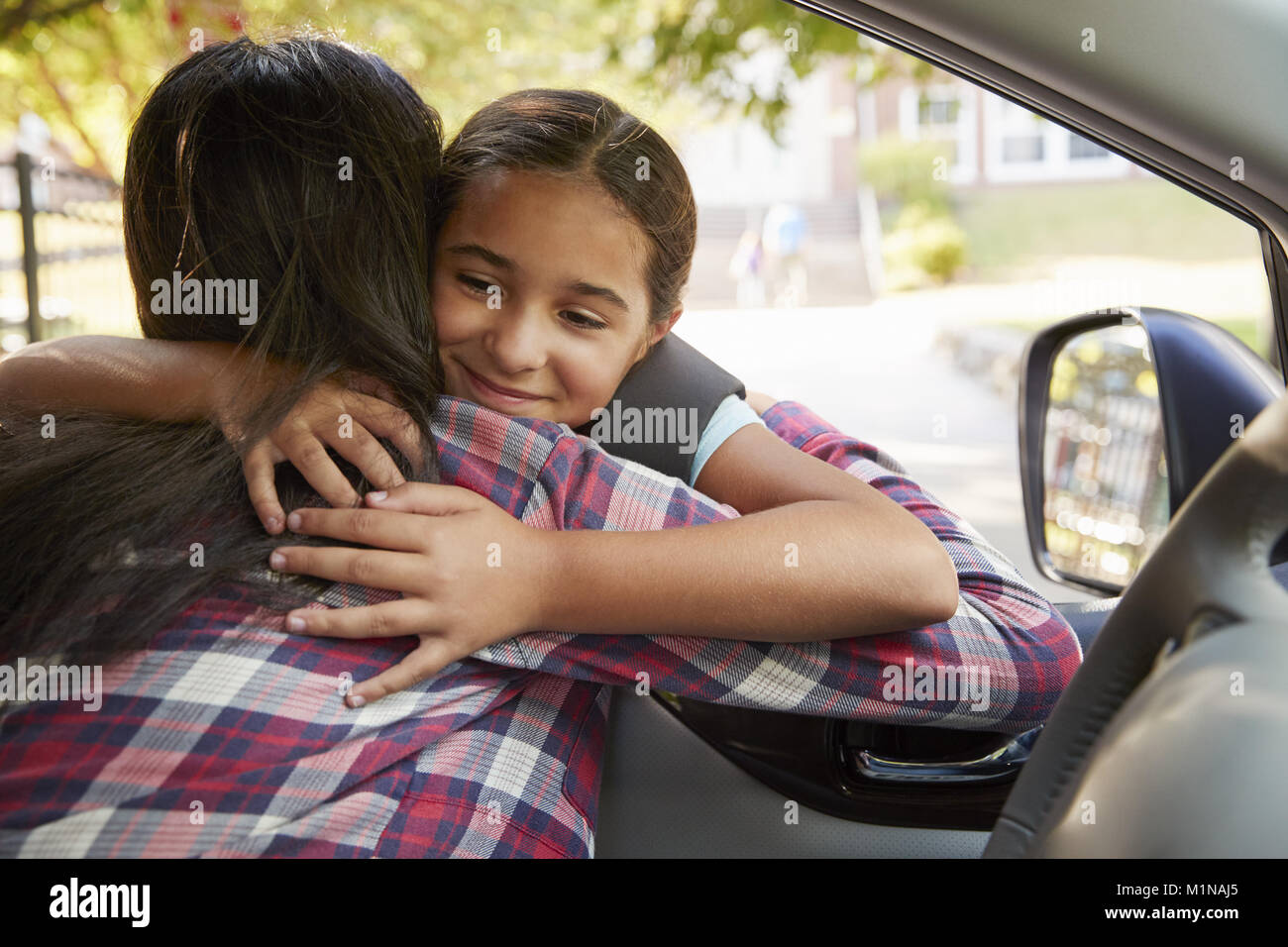 Mother In Car Dropping Off Daughter In Front Of School Gates Stock Photo