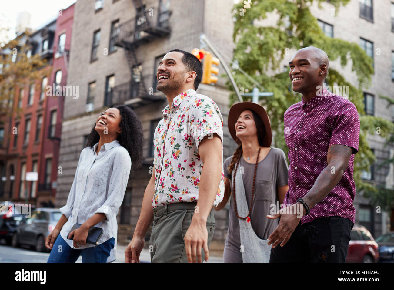Group Of Friends Walking Along Urban Street In New York City Stock Photo