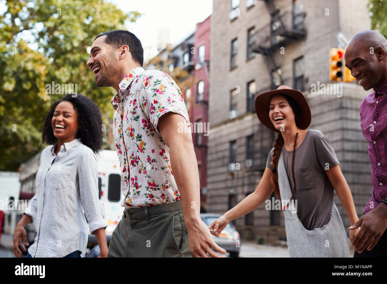 Group Of Friends Walking Along Urban Street In New York City Stock Photo