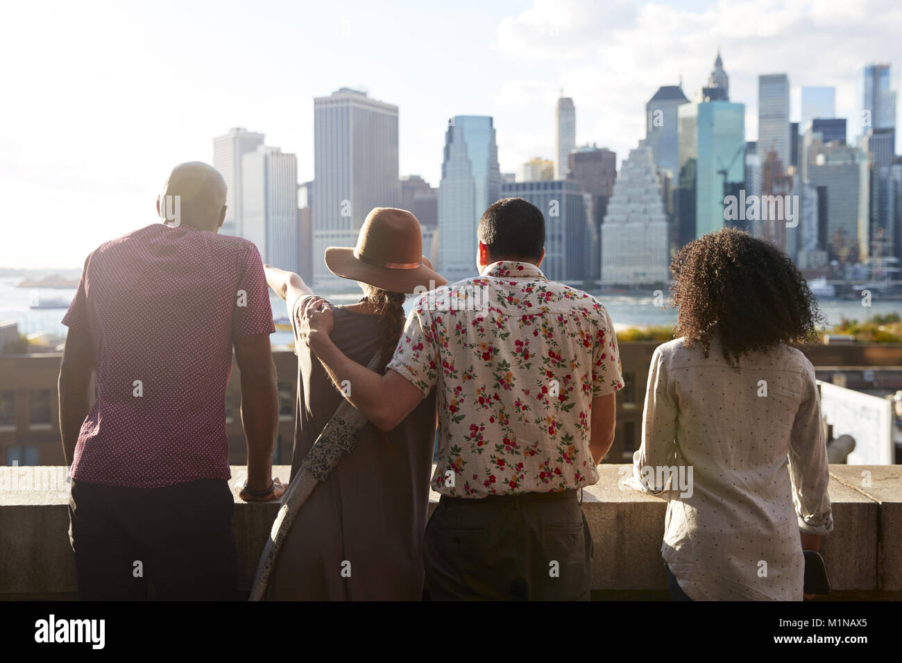 Rear View Of Tourists Looking At Manhattan Skyline Stock Photo